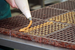 Honey truffles being piped by a Burdick's employee