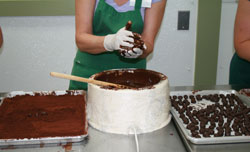 Rolling the truffles in liquid chocolate by hand